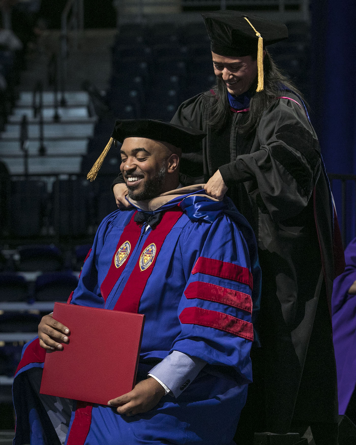 Driehaus College of Business doctoral graduate Brandon Hendrix receives his hood during the DePaul University commencement ceremony.